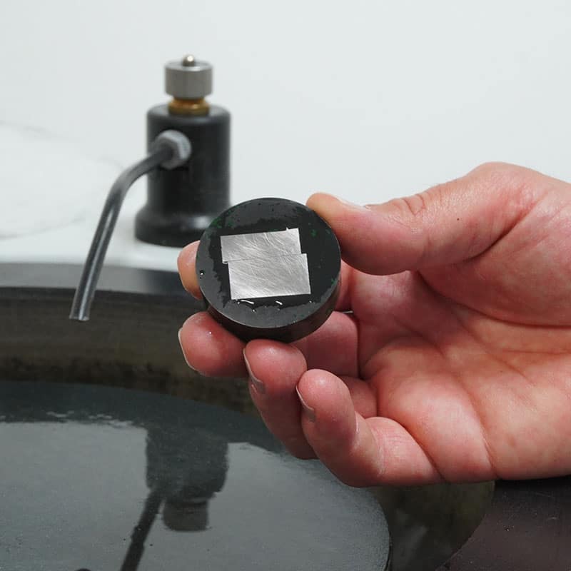 Campione di acciaio lucidato per esame metallografico, pronto per osservazione al microscopio e analisi della microstruttura.
